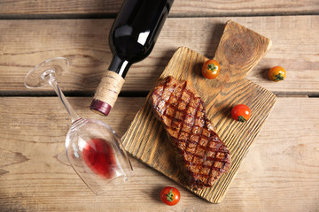 Sticker - Grilled steak on cutting board with wine and cherry tomatoes, closeup