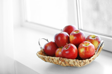 Wall Mural - Ripe red apples in a wicker basket on windowsill