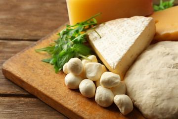 Sticker - Fresh Italian pizza dough with different kinds of cheese on wooden background