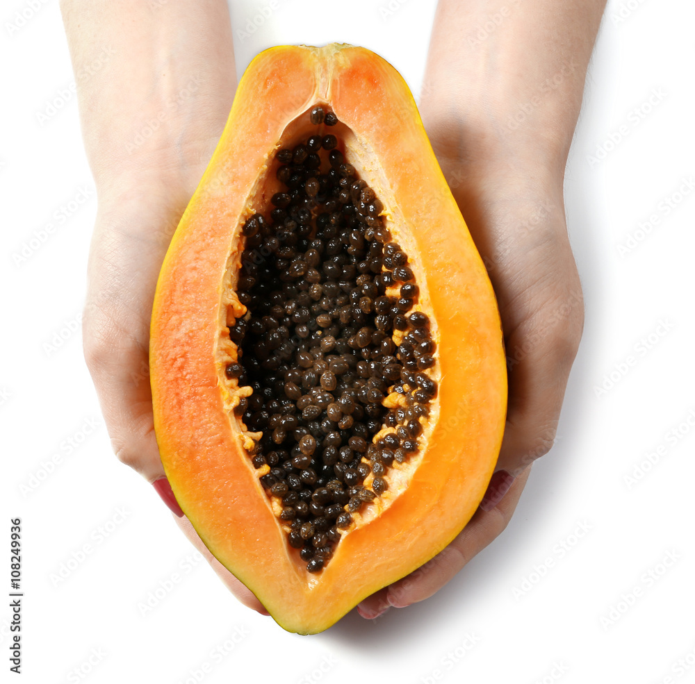 Female hands holding a halved papaya on white background