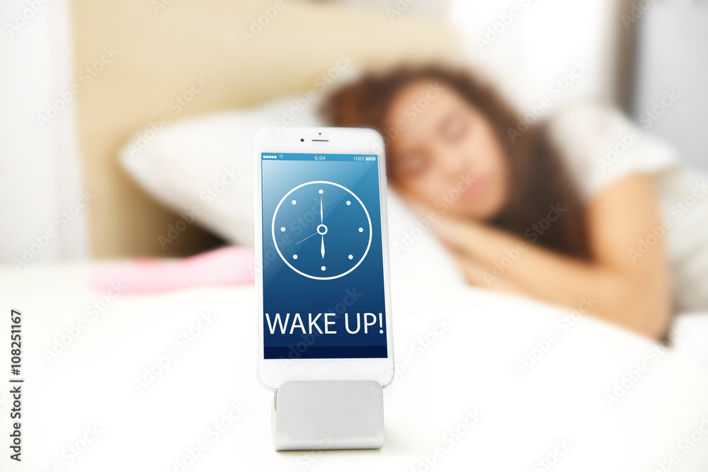 Mobile alarm clock and sleeping girl in bedroom