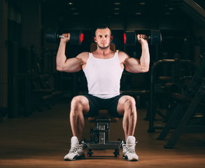 sport, bodybuilding, weightlifting, lifestyle and people concept - young man with dumbbells flexing muscles in gym