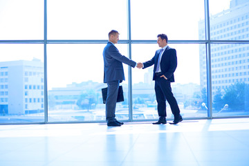 Canvas Print - Full length image of two successful business men shaking hands with each other