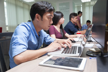 Poster - Asian Businessman Sitting At Desk Working Laptop Computer Busine