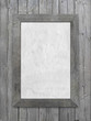 Vertical old gray wooden frame with aged paper hanging on wooden boards background.