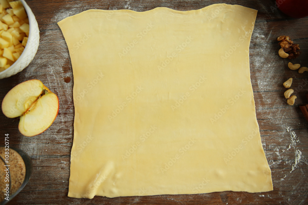 Dough for apple pie on kitchen table