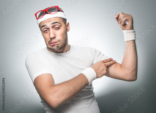 Fotografia, Obraz Crazy man testing the flabby muscle under her arm - biceps pulling it down with her hand as she checks for muscle tone or weight gain