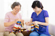 © Tom Wang - happy Senior mother and  daughter  learning knitting