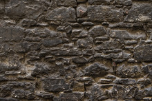 Dark Brown Old Medieval Natural Stone Wall. Texture, Background Or Wallpaper.