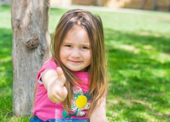 little girl  outdoors shows gestures