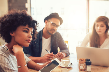 Young people at a cafe with laptop and digital tablet