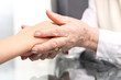 Pomocna dłoń.
Dłoń starszej kobiety przytula dłoń dziecka
