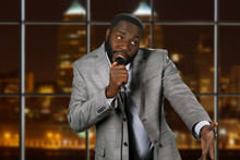 Expressive Black Man With Microphone. Stand-up Comedian On Night Background. Comedy Show On Local Television. Old Funny Story.