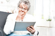 Na emeryturze, rozrywka w internecie. Starsza kobieta serfuje po internecie.