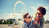 Fototapeta Londyn - happy teenage couple having fun over london