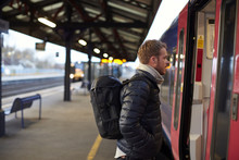 Man Standing On Railway Platform Waiting To Board Train