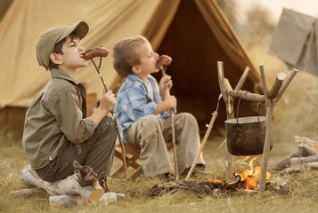 Two of children sitting around the campfire travelers