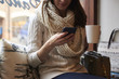 © Guerilla - Young Woman Sitting In Coffee Shop Reading Text Message