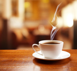 Poster - Cup of coffee on table on blured cafe background