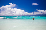 Fototapeta Dmuchawce - Tropical beach, man enjoy turquoise waves of ocean