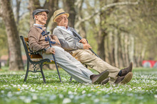 Two Seniors Sitting And Relaxing In A Park