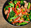 Beef and vegetables stir fry on wooden table.