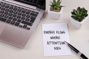 Inspiration motivation quotation Energy flows where attention goes on work desk. Success, Self development concept