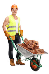 Canvas Print - Worker with a wheelbarrow full of bricks