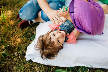 Wall Mural - Young father with daughter having fun outdoors at picnic in the park.