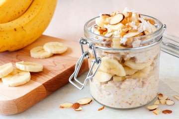 bananas nut overnight oats with in snap lid glass jar on white marble