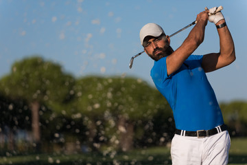 pro golfer hitting a sand bunker shot