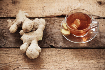 Wall Mural - cup of ginger tea on a wooden table