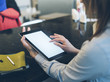 © A_B_C - Girl pointing finger to an blank display of the tablet with a blue color in a home atmosphere on warm bokeh background lighting color, female hands using computer in cafe with reflection and glare