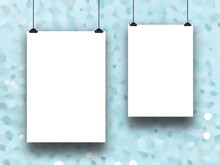 Close-up Of Two Blank Frames Hanged By Clips Against Aqua Out Of Focus Abstract Background
