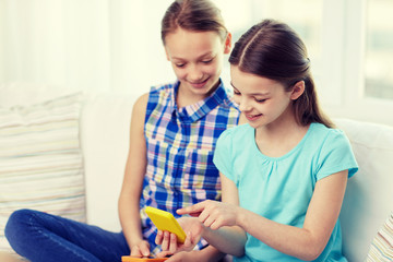 Poster - happy girls with smartphones sitting on sofa