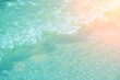 Soft wave of the turquoise sea on the sandy beach. Natural summer background with copy space