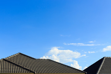 Canvas Print - black tile roof on a new house with clear blue sky background