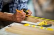 © Wavebreak Media - Carpenter marking on wooden plank with pencil