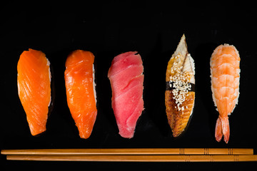 Canvas Print - assortment of nigiri sushi on a dark background, top view