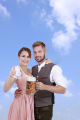 Wall Mural - Junges bayrisches Paar in Tracht mit Bierglas