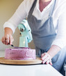 © annaia - kvinna jämnar till tårtan med en spatel