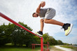 © Syda Productions - young man jumping on horizontal bar outdoors