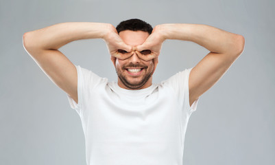 Wall Mural - man making finger glasses over gray background