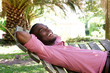 © mimagephotos - Relaxed young man lying outdoors on a hammock