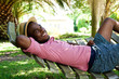 © mimagephotos - Young african man relaxing outdoors on a hammock