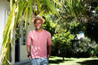 © mimagephotos - Happy young man standing relaxed at his backyard