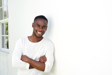 Wall Mural - Handsome young african man standing with his arms crossed