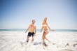 © WavebreakmediaMicro - Happy couple having fun in water on shore