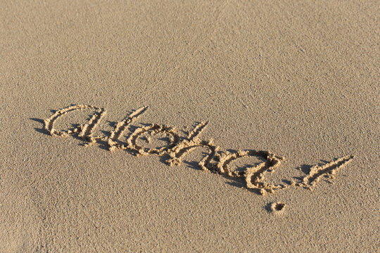 Inscription Aloha on sandy beach