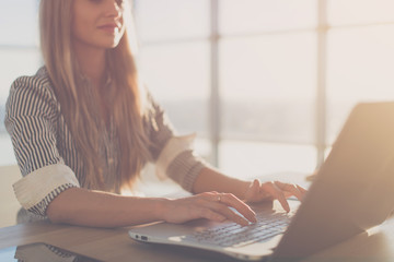 female writer typing using laptop keyboard at her workplace in the morning. woman writing blogs onli
